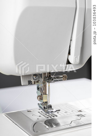 Modern white sewing machine presser foot closeup, macro 103836493