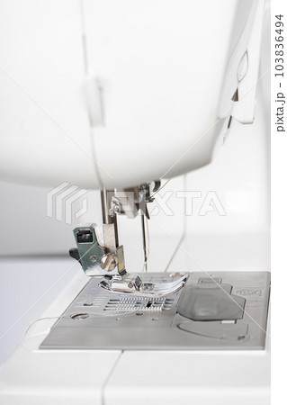 Modern white sewing machine presser foot closeup, macro 103836494