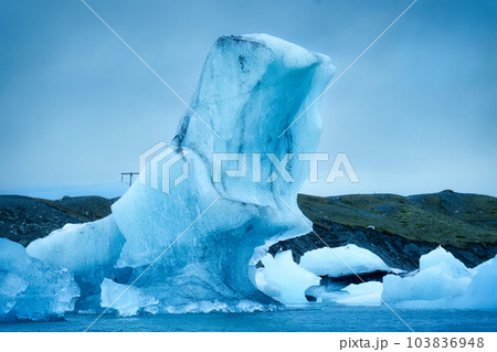 Natural blue iceberg floating and melting in Jokulsarlon glacier lagoon Natural blue iceberg floating and melting in Jokulsarlon glacier lagoon 103836948