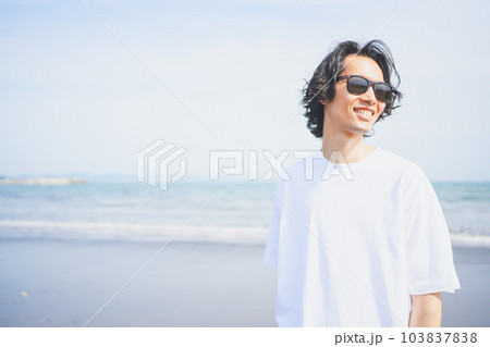 夏の海岸を歩くサングラスをかけた男性 夏の海岸を歩くサングラスをかけた男性 103837838