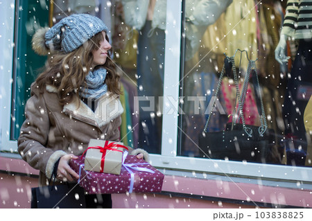 girl holding a set of gifts near the store 103838825