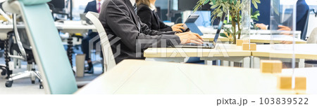 フリーアドレスのオフィスで仕事をするビジネスマンのイメージカット 103839522