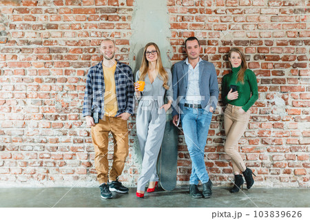 Team of people in startup company standing on brick wall 103839626