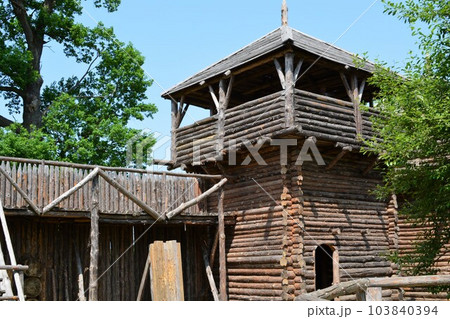 Ancient medieval wooden wall with a lookout wooden tower. 103840394