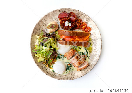 Poached egg with sun-dried tomatoes, bacon roll, prosciutto, and lettuce Poached egg with sun-dried tomatoes, bacon roll, prosciutto, and lettuce 103841150