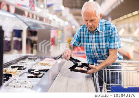elderly retired senor buying sushi in buffet department of supermarket elderly retired senor buying sushi in buffet department of supermarket 103843176