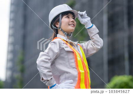 工事現場で働くヘルメット姿の若い女性 工事現場で働くヘルメット姿の若い女性 103845627