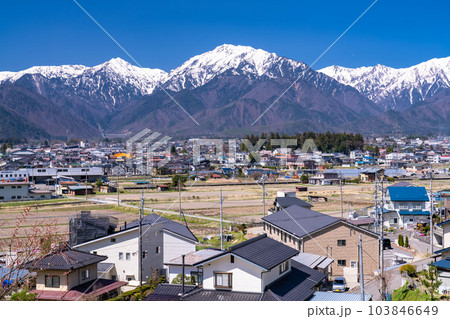 《長野県》長野県大町市・北アルプスと住宅街の風景 103846649