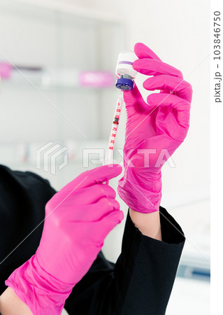 Close-up of female beautician doctor holding syringe with beauty injections Close-up of female beautician doctor holding syringe with beauty injections 103846750