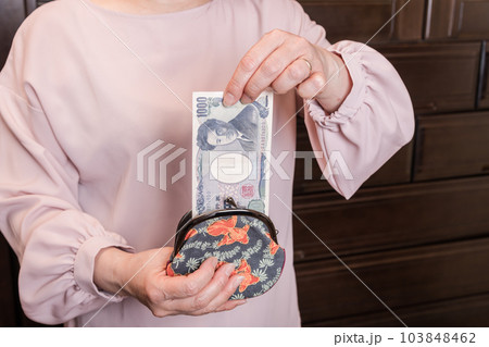 【がま口から1000円札を出す主婦】 【がま口から1000円札を出す主婦】 103848462