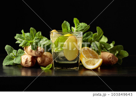 Cold refreshing drink with ice, ginger, lemon, and mint. 103849643