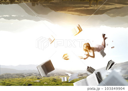 Young woman levitates while reading a book Young woman levitates while reading a book 103849904