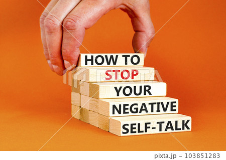 Stop negative self-talk symbol. Concept words How to stop your negative self-talk on wooden block. Psychologist hand. Beautiful orange background. Psychological negative self-talk concept. Copy space Stop negative self-talk symbol. Concept words How to stop your negative self-talk on wooden block. Psychologist hand. Beautiful orange background. Psychological negative self-talk concept. Copy space 103851283