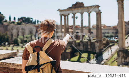 Young man tourist in sunglasses resting at Roman Forum. Historical imperial Foro Romano from panoramic point of view, Italy. Concept of travel, tourism and vacation in city. Young man tourist in sunglasses resting at Roman Forum. Historical imperial Foro Romano from panoramic point of view, Italy. Concept of travel, tourism and vacation in city. 103854438