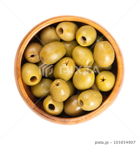 Pitted green olives, in a wooden bowl. Organic olives from Italy. Picked as semi-ripe and turning-color olives, with reddish-green color, preserved in salt. Used as a snack, appetizer or as garnish. 103854907
