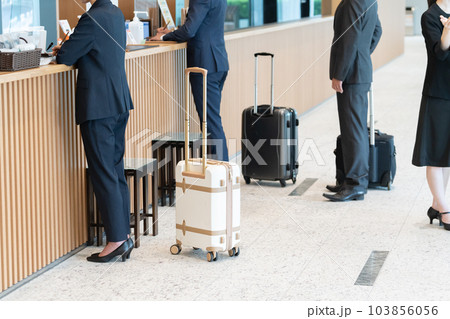 ホテルのフロントで手続きするビジネスマン（出張・予約） 103856056