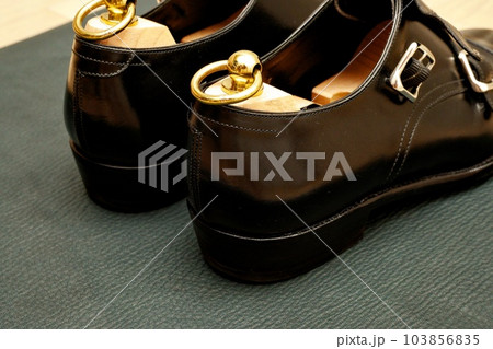 ピカピカに磨いた黒いダブルモンクストラップの革靴 103856835