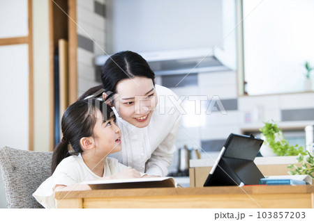 自宅で娘に勉強を教える母親 103857203