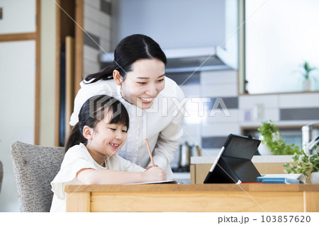 自宅で娘に勉強を教える母親 103857620