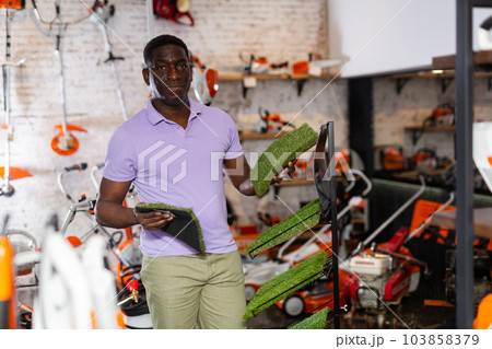 Man with patterns of synthetic grass in store 103858379
