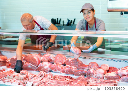Young female butcher showing raw veal loin slices in butchery 103858490