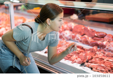 Female customer points with finger and orders beef brisket and sirloin 103858611