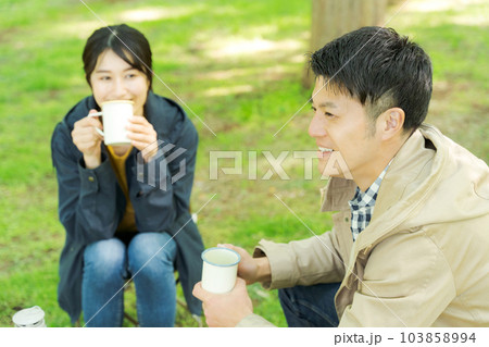屋外でコーヒーを飲む男女の写真 103858994
