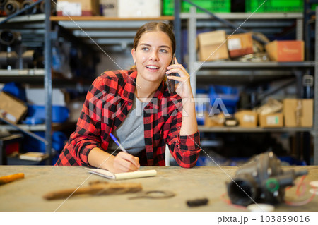 Smiling young woman storehouse worker talking on phone 103859016