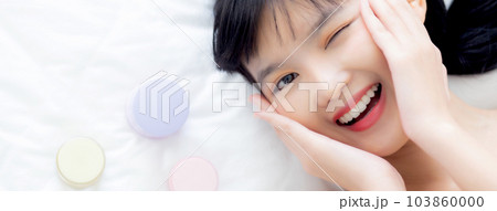 Beautiful of young asian woman smiling and lying on bed with cosmetic at bedroom. Beautiful of young asian woman smiling and lying on bed with cosmetic at bedroom. 103860000