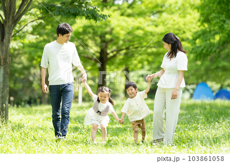 手をつないで歩く若い家族 103861058
