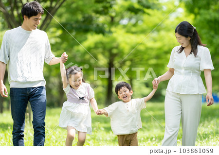 手をつないで歩く若い家族 103861059