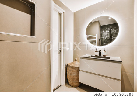 a bathroom with a mirror on the wall and a toilet in the corner next to the sink is also white 103861589