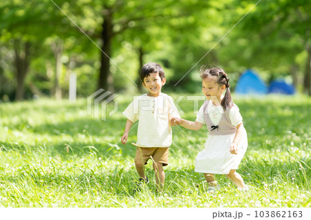 手をつないで走る男の子と女の子 手をつないで走る男の子と女の子 103862163