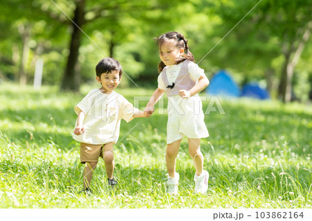 手をつないで走る男の子と女の子 103862164
