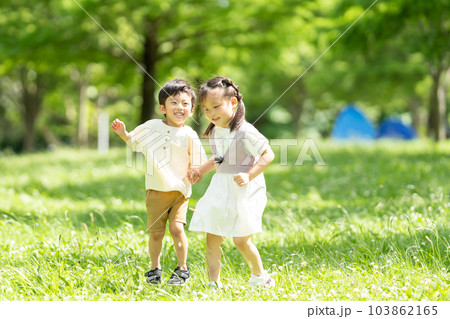 手をつないで走る男の子と女の子 103862165