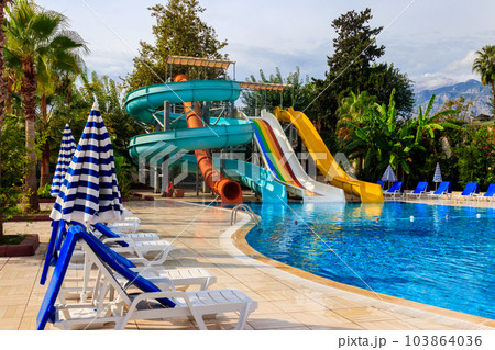 Swimming pool with water slide at the tropic summer resort 103864036