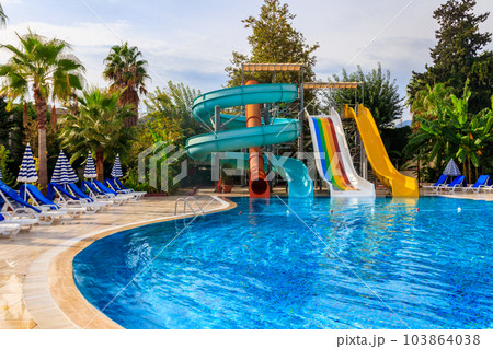 Swimming pool with water slide at the tropic summer resort 103864038