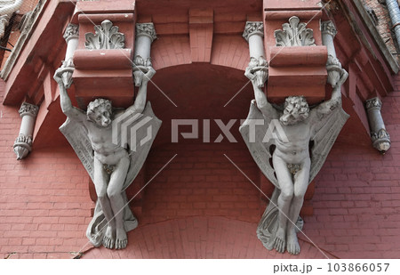 Kiev, Ukraine June 10, 2021: Sculpture of a Griffin head of a lion in a human body with bat wings on the facade of a building in the center of Kiev 103866057