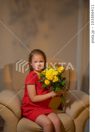 An elegant girl in a red dress with a bouquet...の写真素材