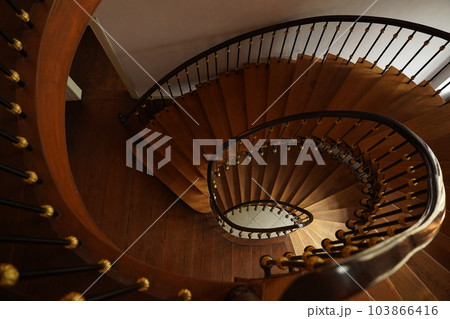 Spiral staircase with wooden railings. 103866416