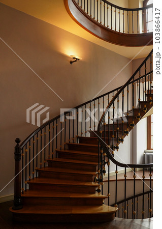 Spiral staircase with wooden railings. 103866417