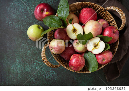 Fruit background, organic fruits. Still life food. Basket of ripe apples on a stone table. View from above. Copy space. Fruit background, organic fruits. Still life food. Basket of ripe apples on a stone table. View from above. Copy space. 103868021
