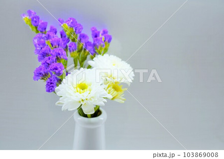 白背景に陶器の花立に活けられた白い菊と紫のスターチスの仏花 白背景に陶器の花立に活けられた白い菊と紫のスターチスの仏花 103869008