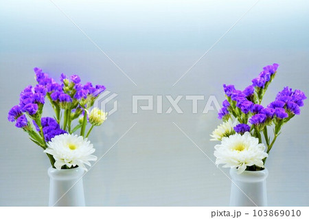 白背景に陶器の花瓶に活けられたホワイトの小菊とパープルのスターチスの仏壇用二セットの花のアップ 白背景に陶器の花瓶に活けられたホワイトの小菊とパープルのスターチスの仏壇用二セットの花のアップ 103869010