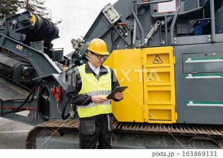 Engineer next to road construction machine. 103869131