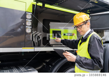 Worker with digital tablet operating construction machine 103869146