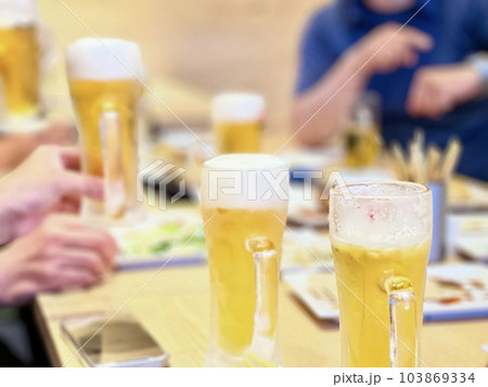 たくさんのビールジョッキが並んで盛り上がる宴会のテーブル たくさんのビールジョッキが並んで盛り上がる宴会のテーブル 103869334