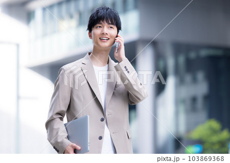 ビジネス　屋外を歩く若いビジネスマン 103869368