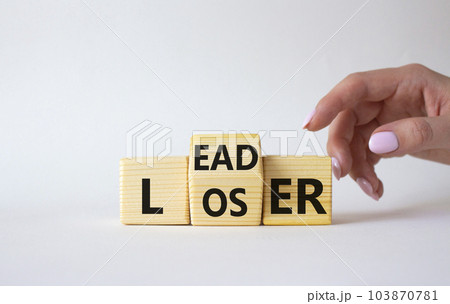 Leader vs Loser symbol. Businessman hand points at wooden cubes with words Loser and Leader. Beautiful white background. Leader vs Loser and business concept. Copy space Leader vs Loser symbol. Businessman hand points at wooden cubes with words Loser and Leader. Beautiful white background. Leader vs Loser and business concept. Copy space 103870781