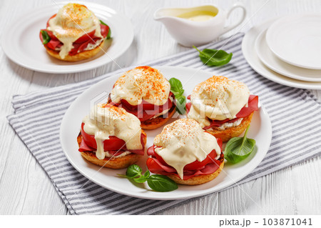 Eggs Benedict on white plate, top view Eggs Benedict on white plate, top view 103871041